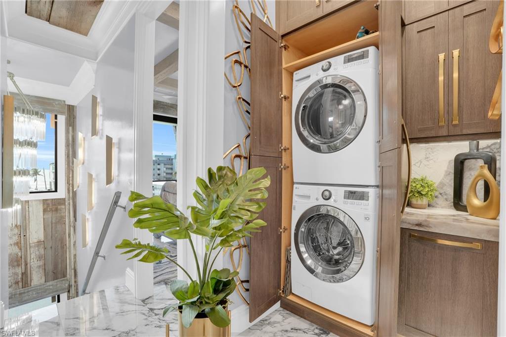 Washroom featuring light marble finish floors and stacked washer and clothes dryer - Virtually Edited Image
