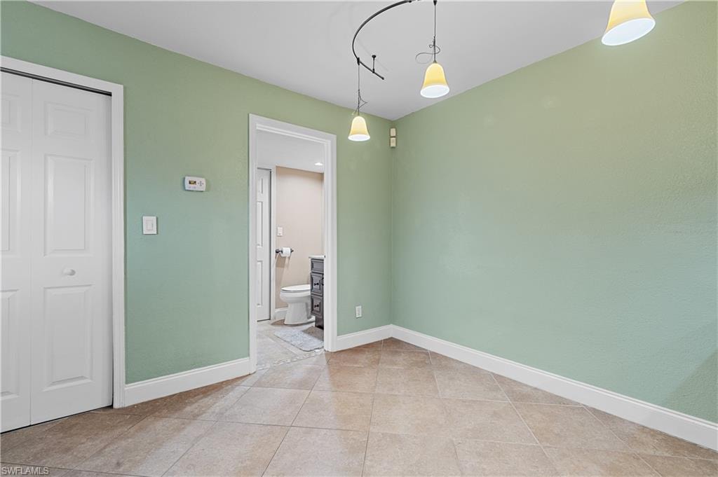 Unfurnished dining area featuring baseboards and light tile patterned floors