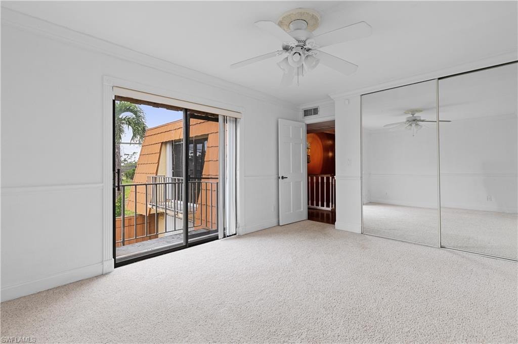 Unfurnished bedroom featuring carpet flooring, crown molding, access to exterior, a closet, and a ceiling fan