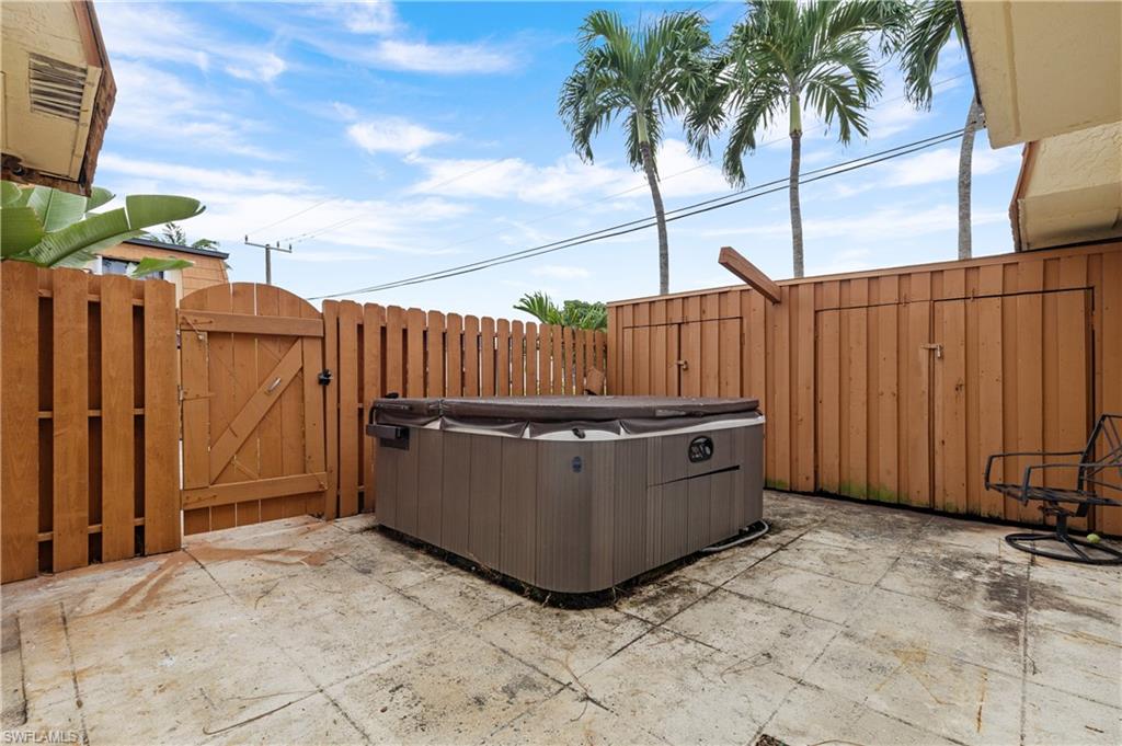 View of patio featuring a gate and a hot tub