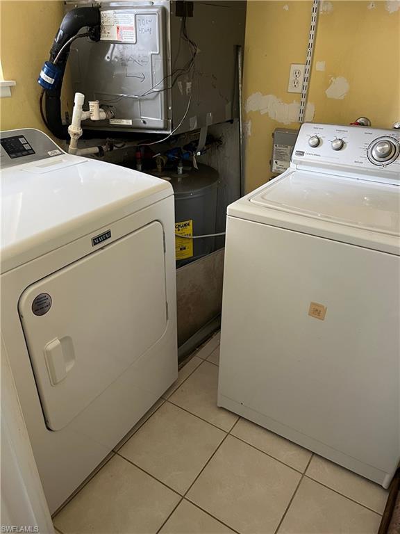 Laundry room featuring light tile patterned floors and washing machine and dryer