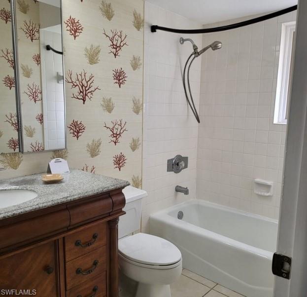 Full bathroom featuring tile patterned flooring, vanity, toilet, and tiled shower / bath