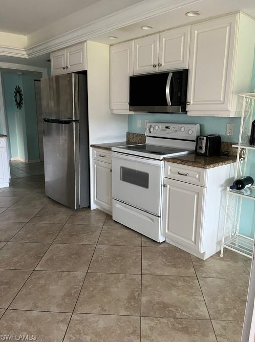 Kitchen featuring stainless steel fridge, crown molding, electric stove, white cabinets, and light tile patterned flooring