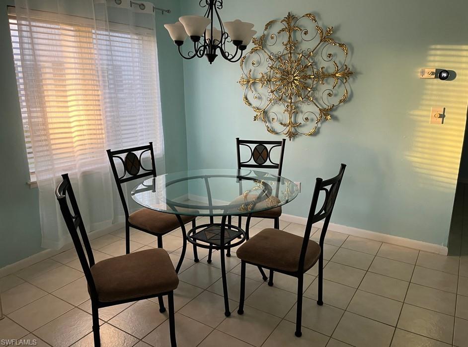 Tiled dining area featuring an inviting chandelier