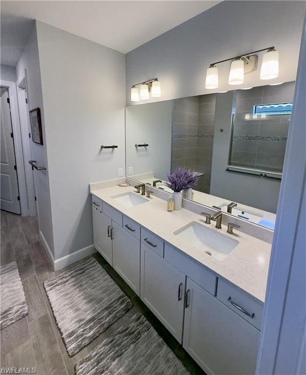Bathroom with double vanity and wood tiled floors