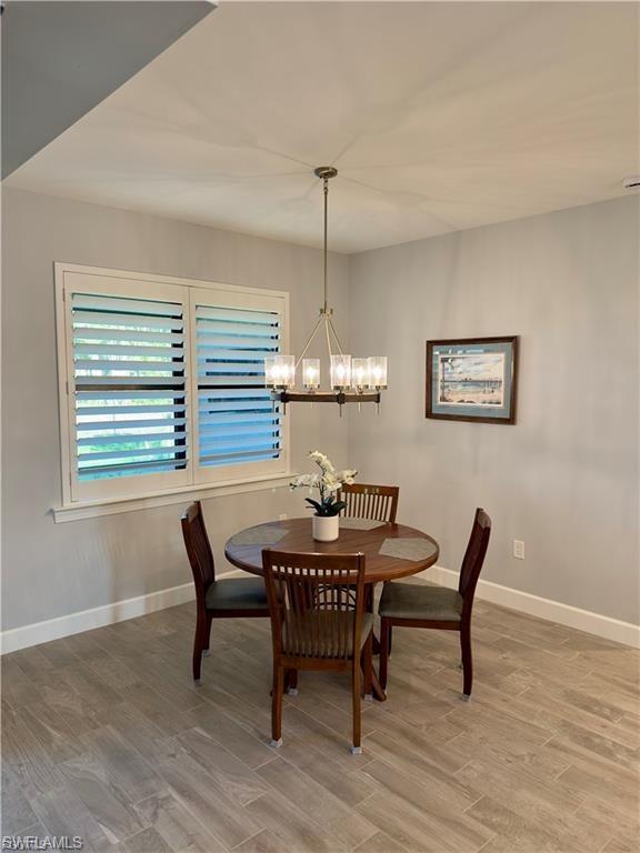 Dining space with light wood finished floors and a chandelier
