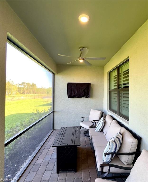 Sunroom with a ceiling fan and an outdoor living space