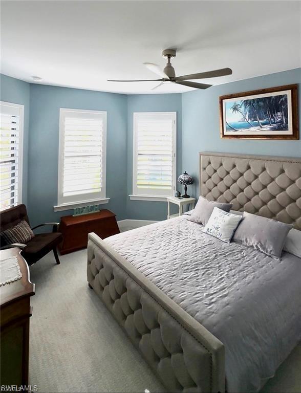 Bedroom with light carpet and a ceiling fan