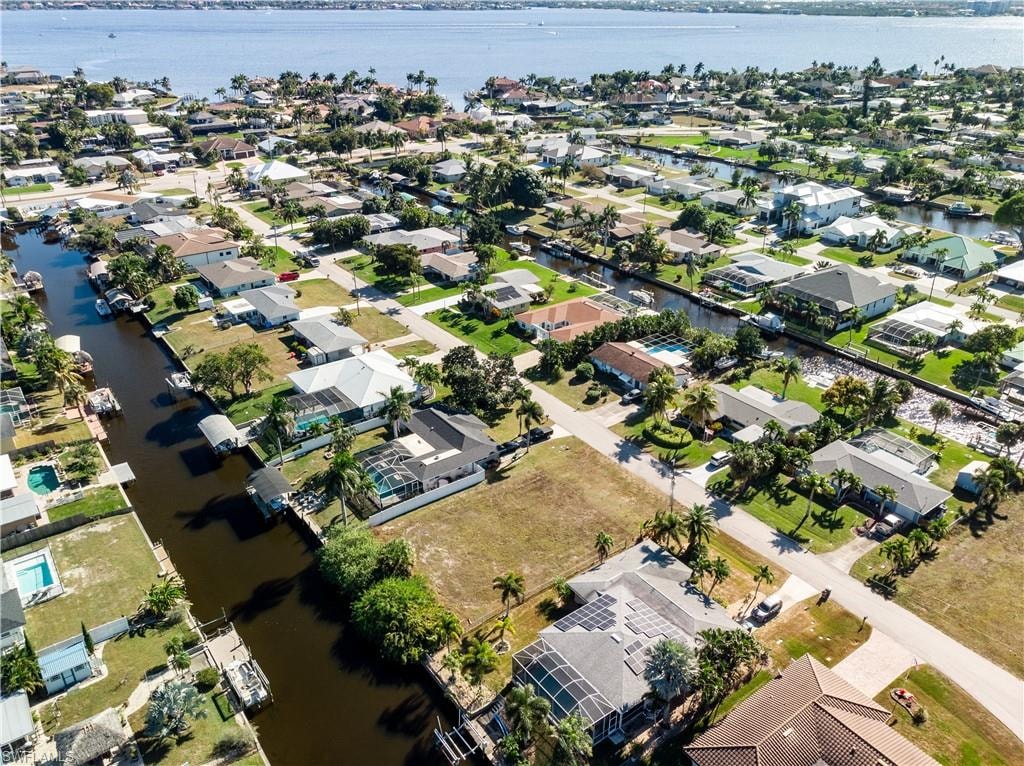 Aerial view of property and surrounding area with nearby suburban area and a nearby body of water