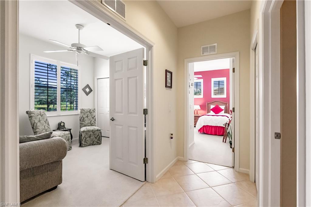Hall featuring light carpet and light tile patterned floors