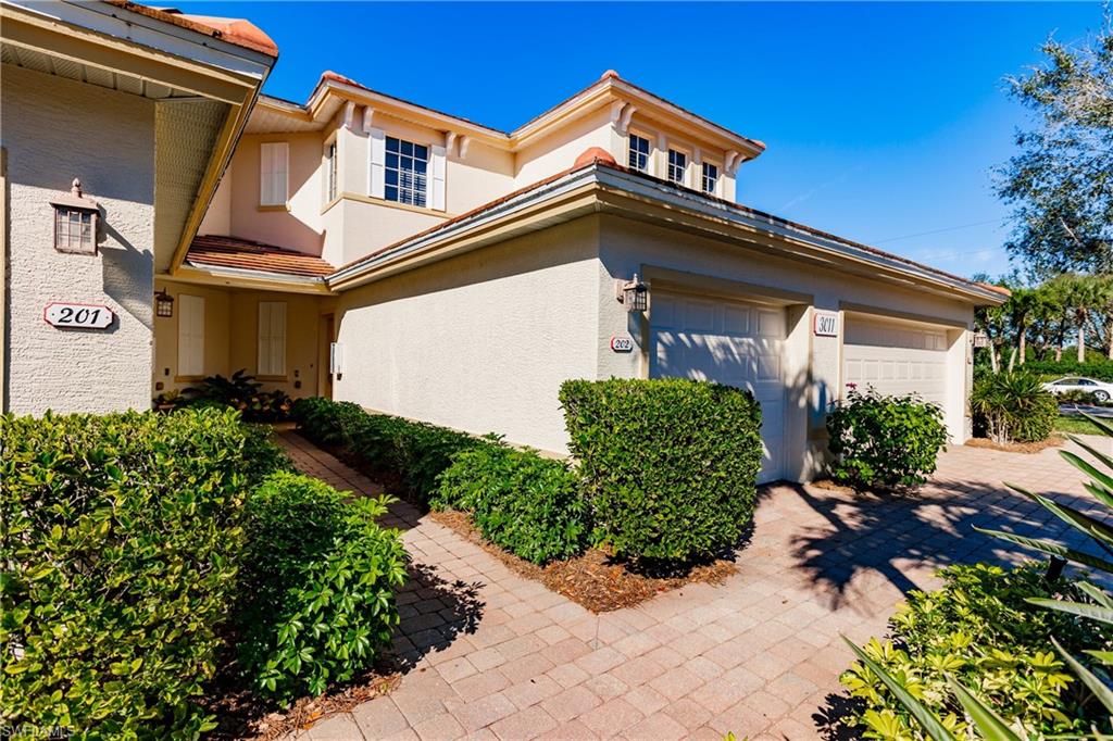 View of exterior entry with stucco siding, a garage, and driveway