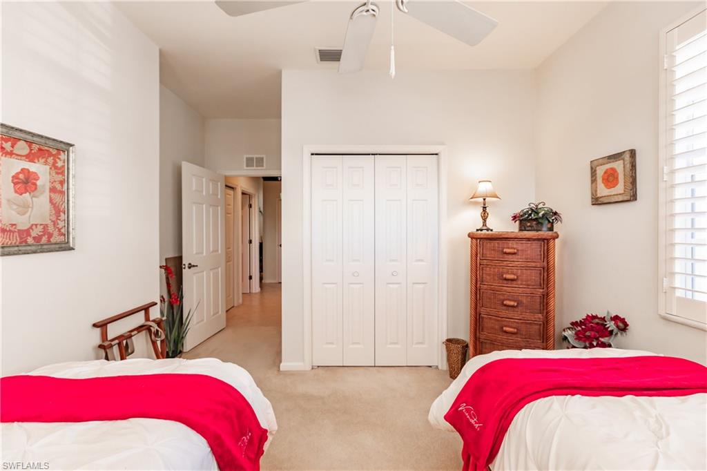 Carpeted bedroom with a closet and ceiling fan