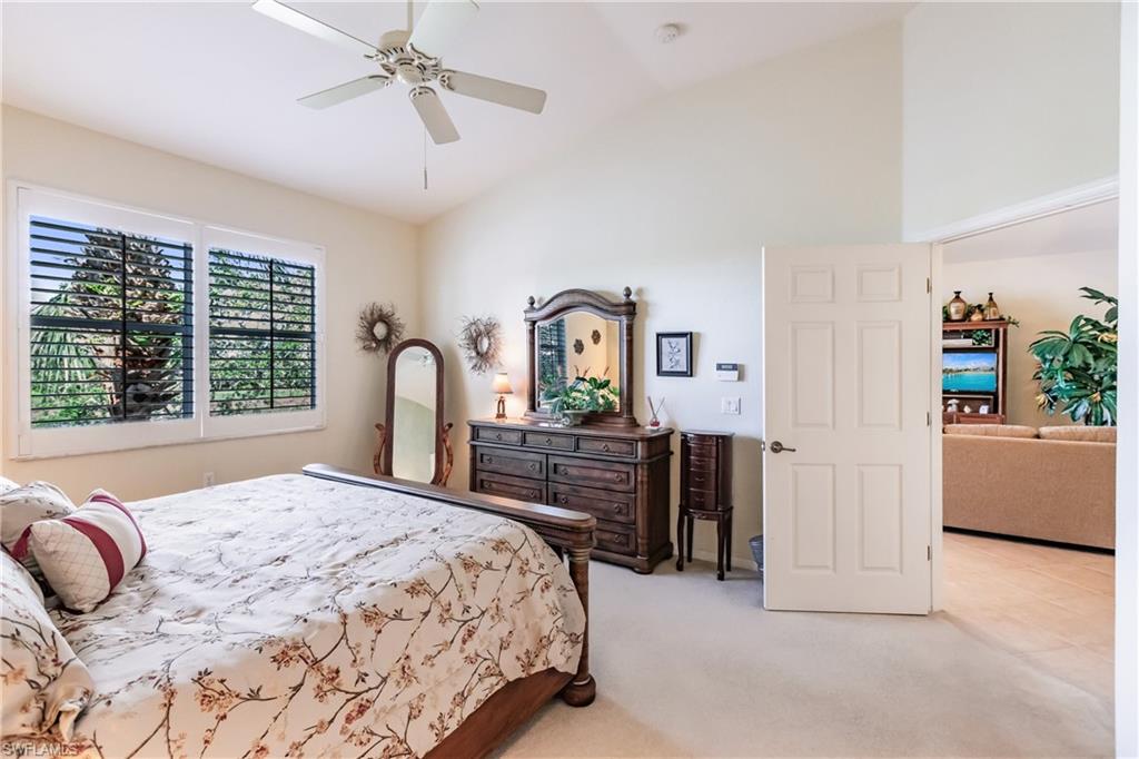 Bedroom featuring vaulted ceiling, light colored carpet, and ceiling fan