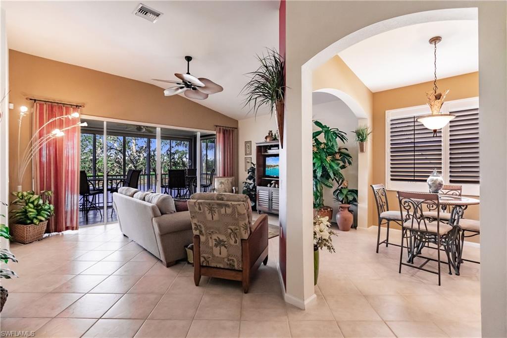 Living area featuring light tile patterned flooring, a ceiling fan, and vaulted ceiling
