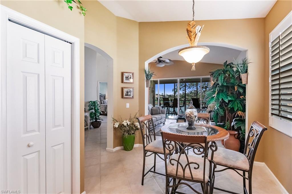 Tiled dining room featuring arched walkways and a ceiling fan