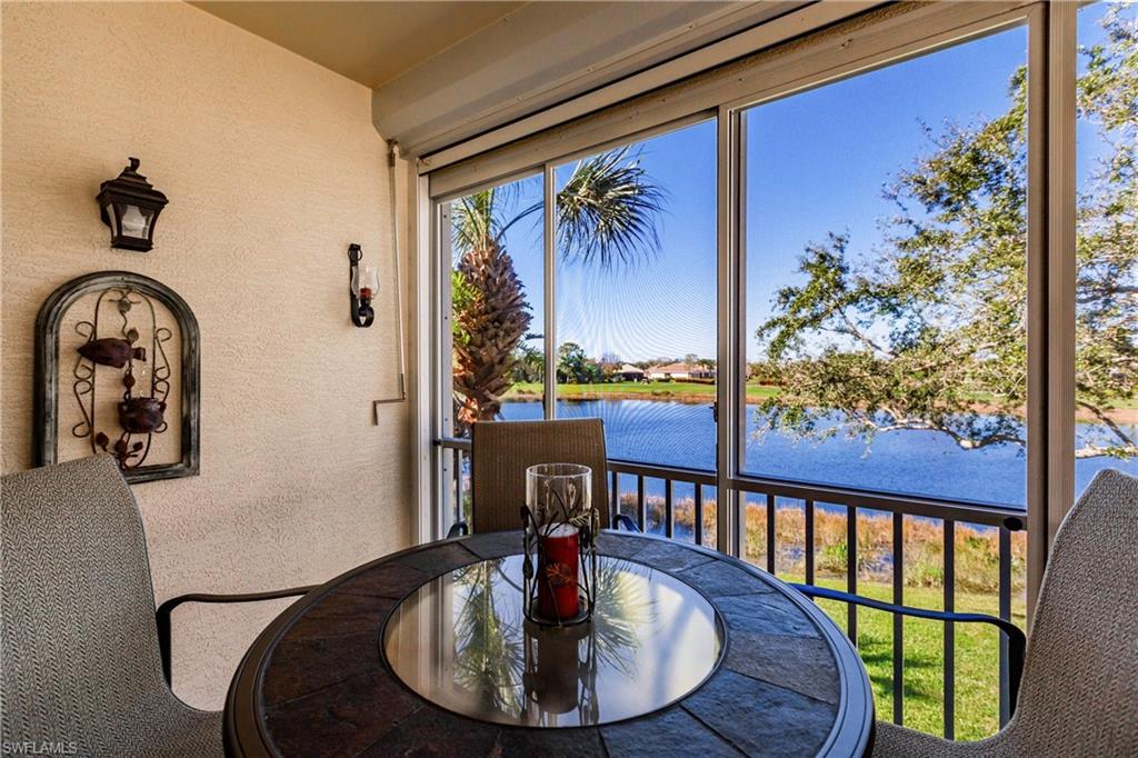 Sunroom with a textured wall and a water view