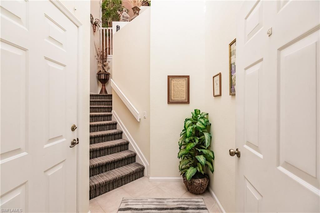 Entrance foyer with light tile patterned floors and stairway