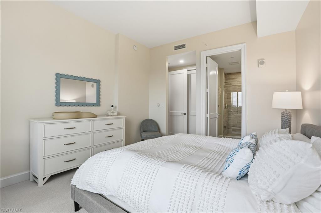 Bedroom with light carpet and ensuite bath