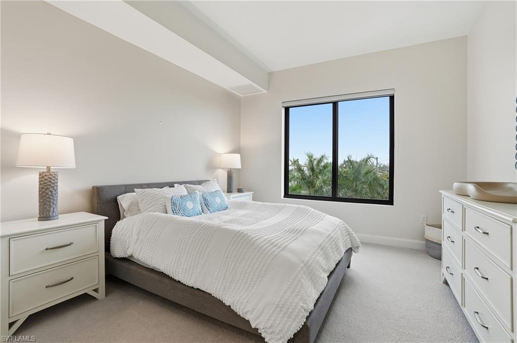 Bedroom featuring light carpet and baseboards