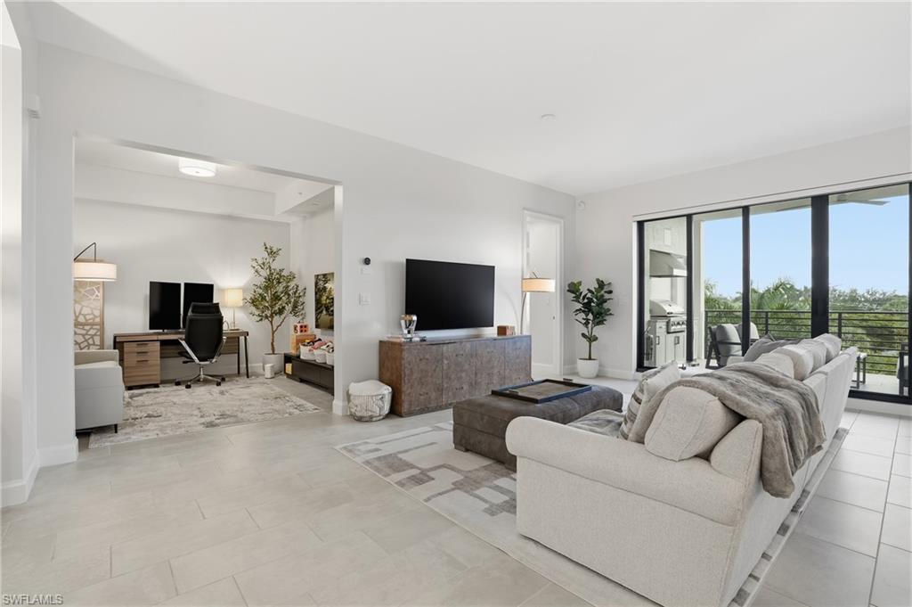 Living room with a desk and light tile patterned floors