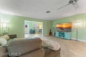 Tiled living room featuring baseboards and ceiling fan