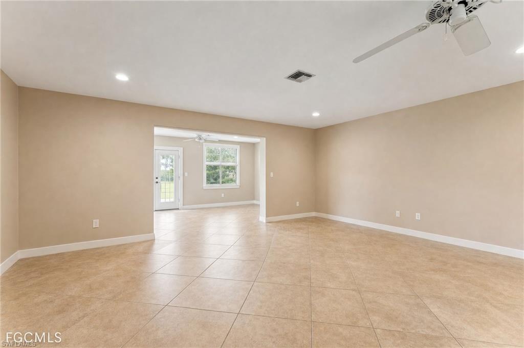 Expansive living area featuring tile flooring, neutral wall tones, recessed lighting, and a ceiling fan. Virtually removed clutter/furniture with light tone walls.