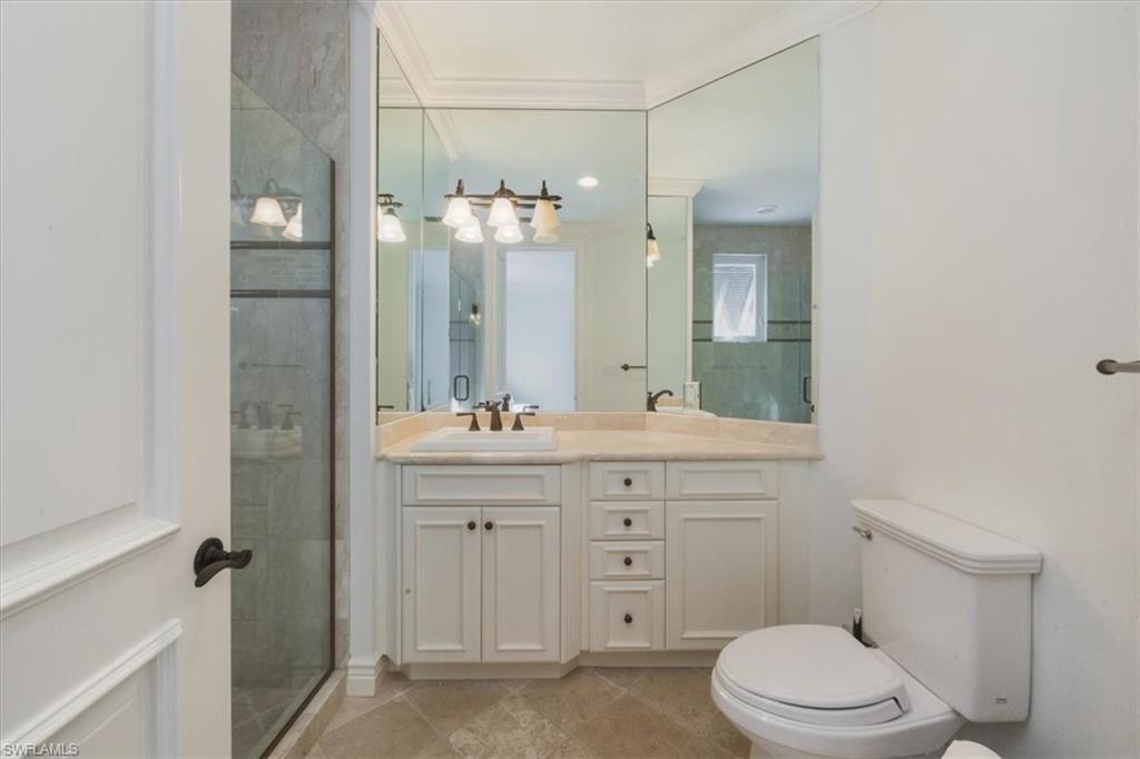 Full bath with vanity, a stall shower, and light tile patterned flooring