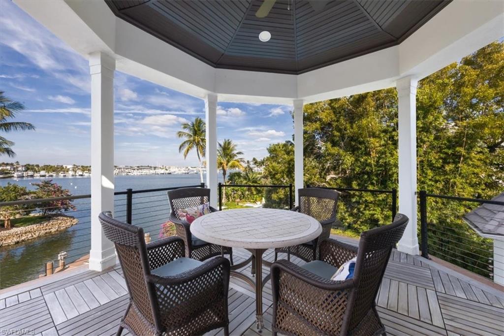 Sunroom featuring a water view and wooden ceiling