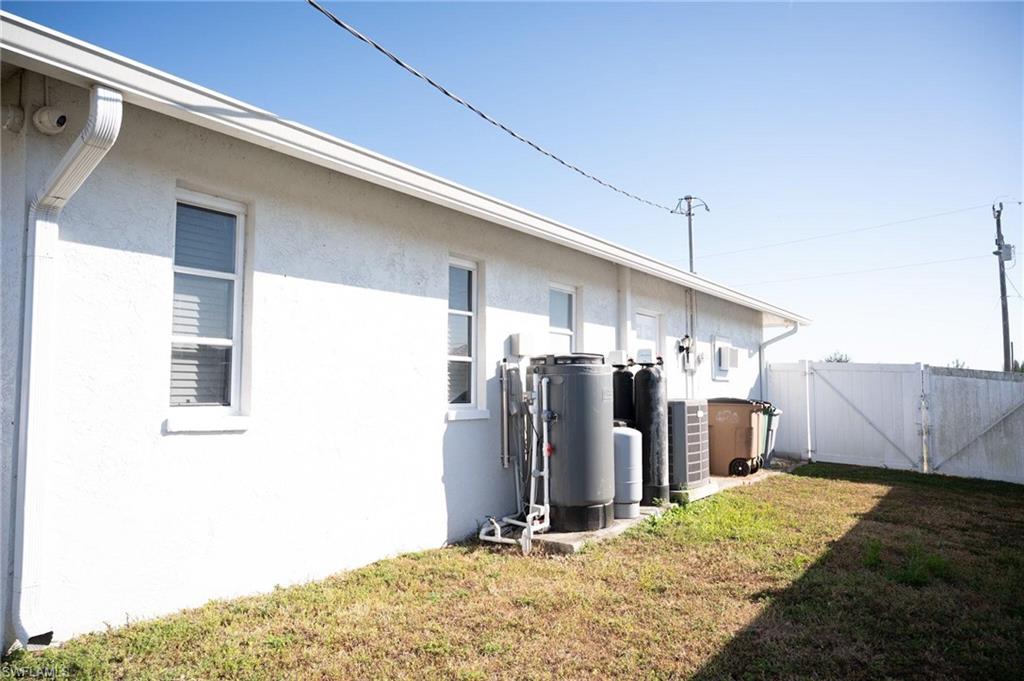 View of home's exterior with stucco siding and a gate