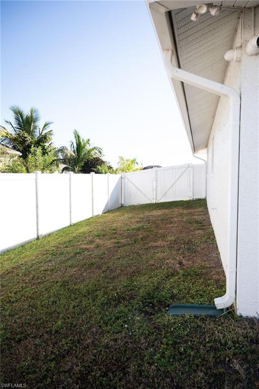 Fenced backyard featuring a gate