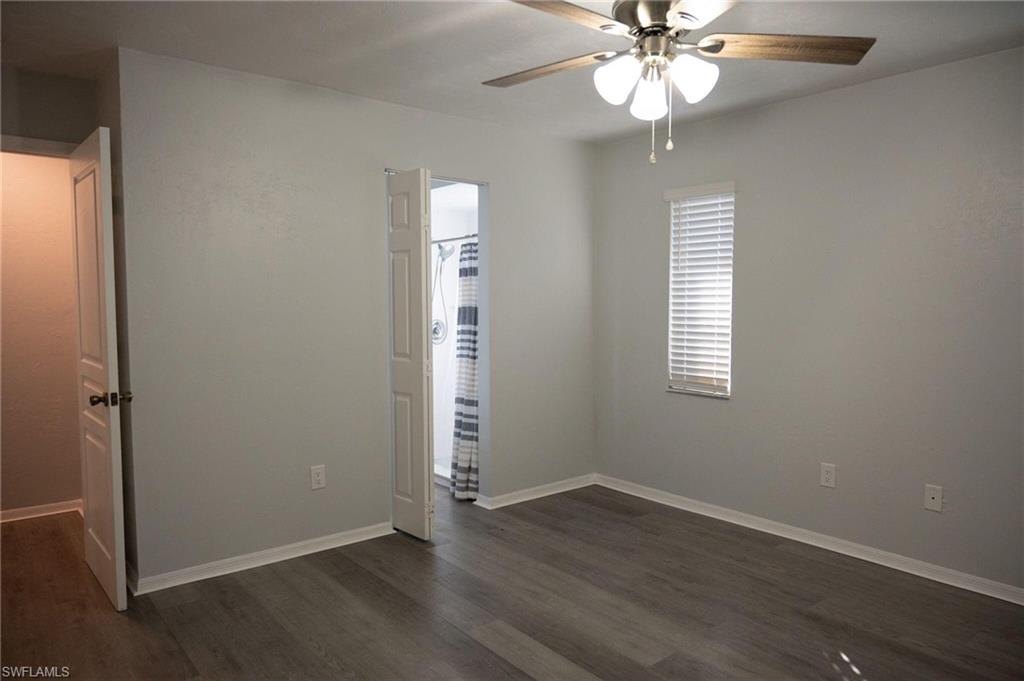 Unfurnished bedroom with dark wood-style flooring and ceiling fan