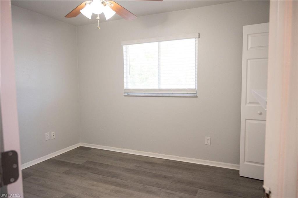 Empty room featuring dark wood-style floors and ceiling fan