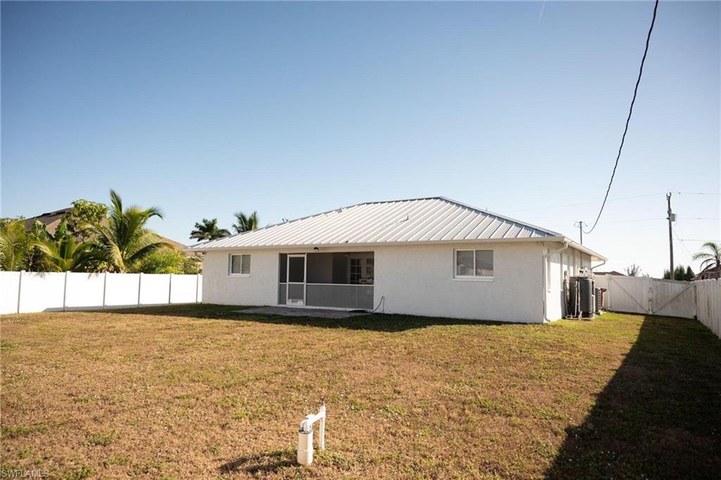 Back of property featuring stucco siding, a fenced backyard, a patio, and a metal roof