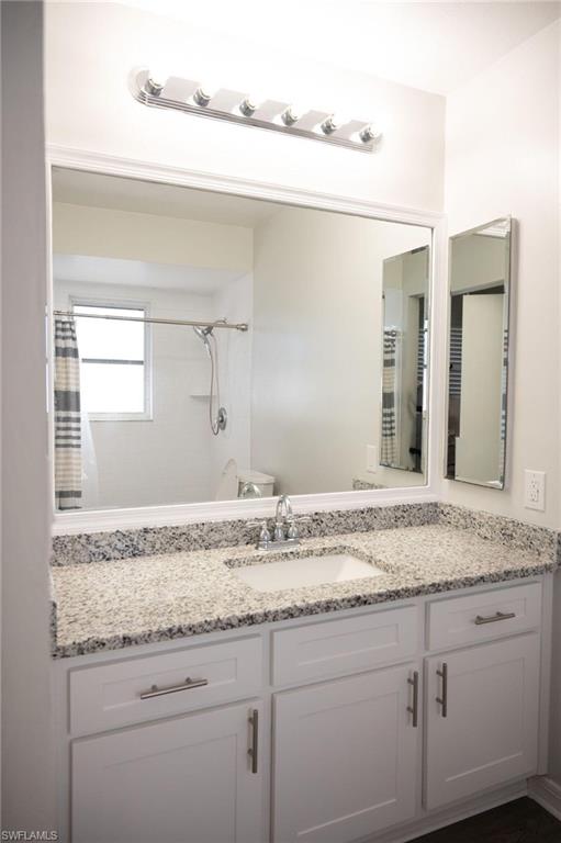 Full bathroom with vanity and curtained shower