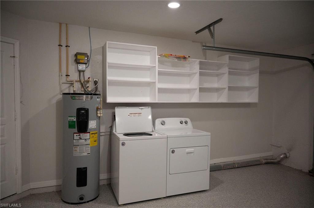Laundry area featuring electric water heater and washer and clothes dryer