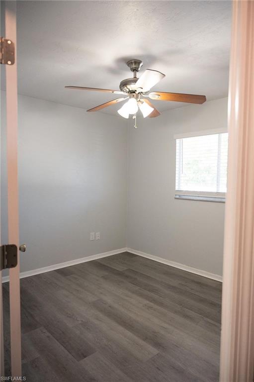 Empty room featuring dark wood finished floors and a ceiling fan
