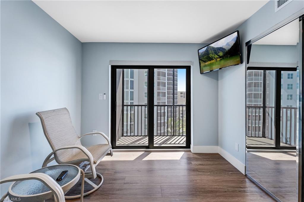 Guest bedroom with wood finished floors and baseboards and a private balcony