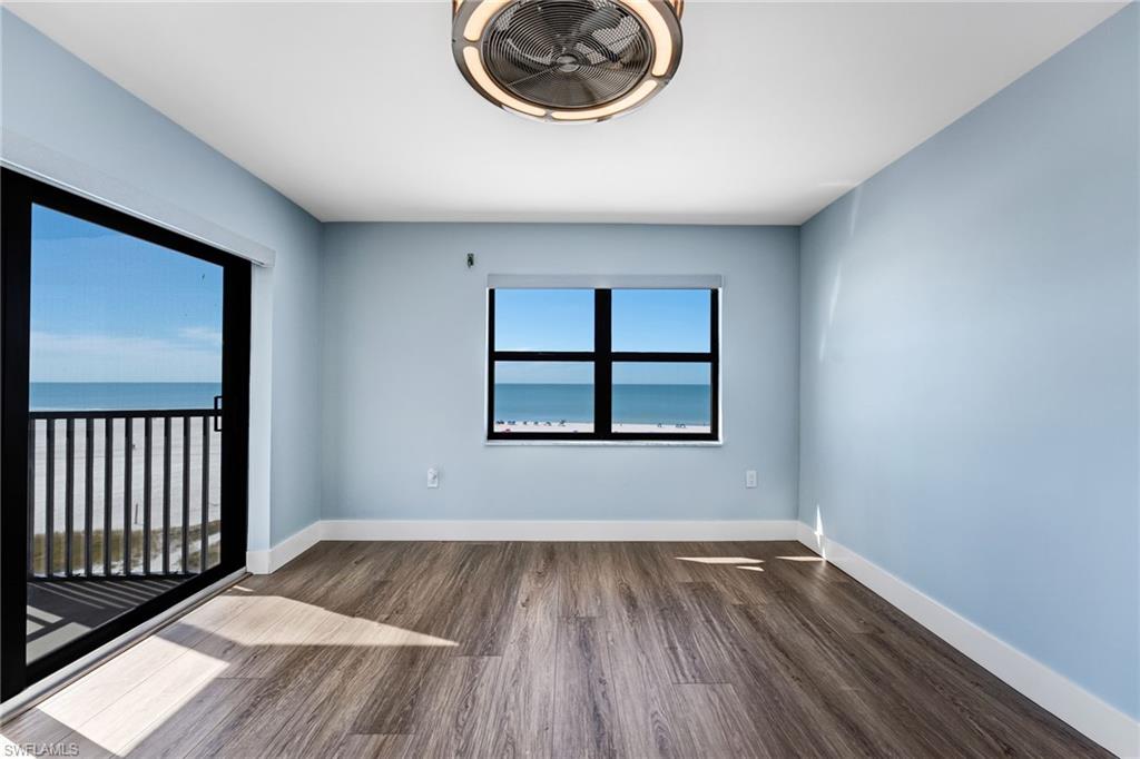 Master bedroom featuring dark wood-type flooring and a water view