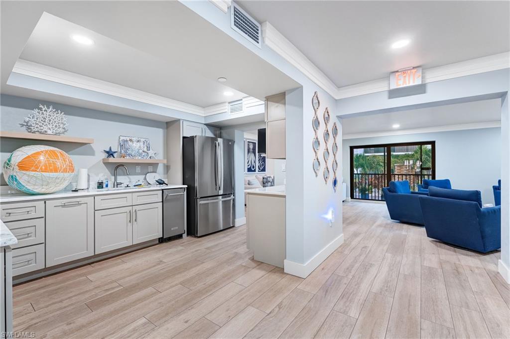 Community Kitchen with ornamental molding, open shelves, stainless steel appliances, light wood-style flooring, and recessed lighting.  Great place for fun gatherings