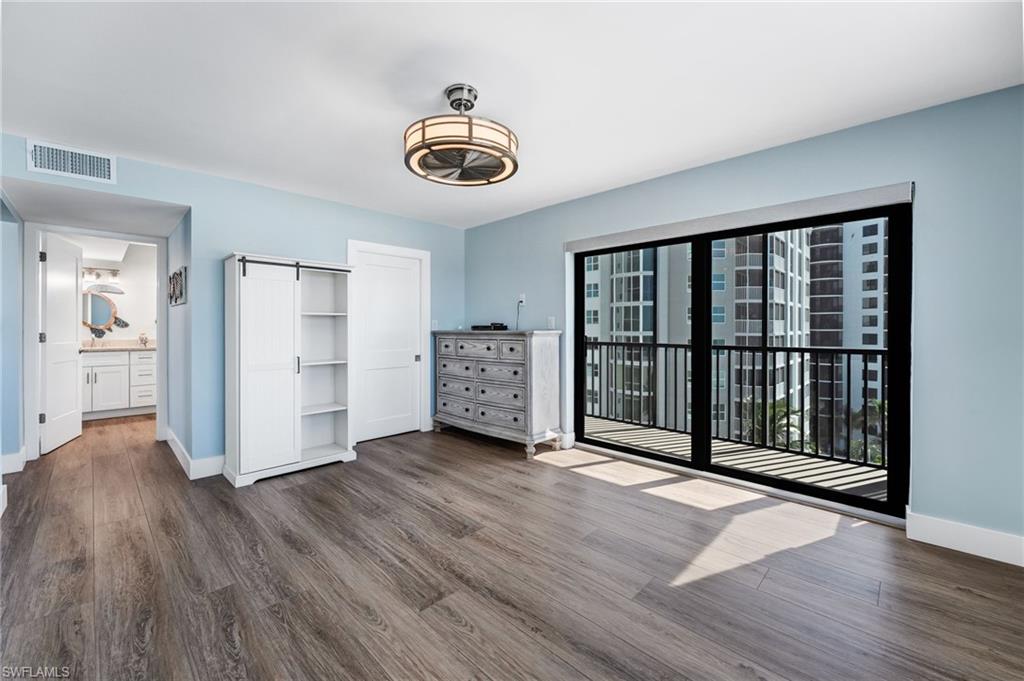 Master bedroom featuring dark wood-style floors, access to outside, and ensuite bath