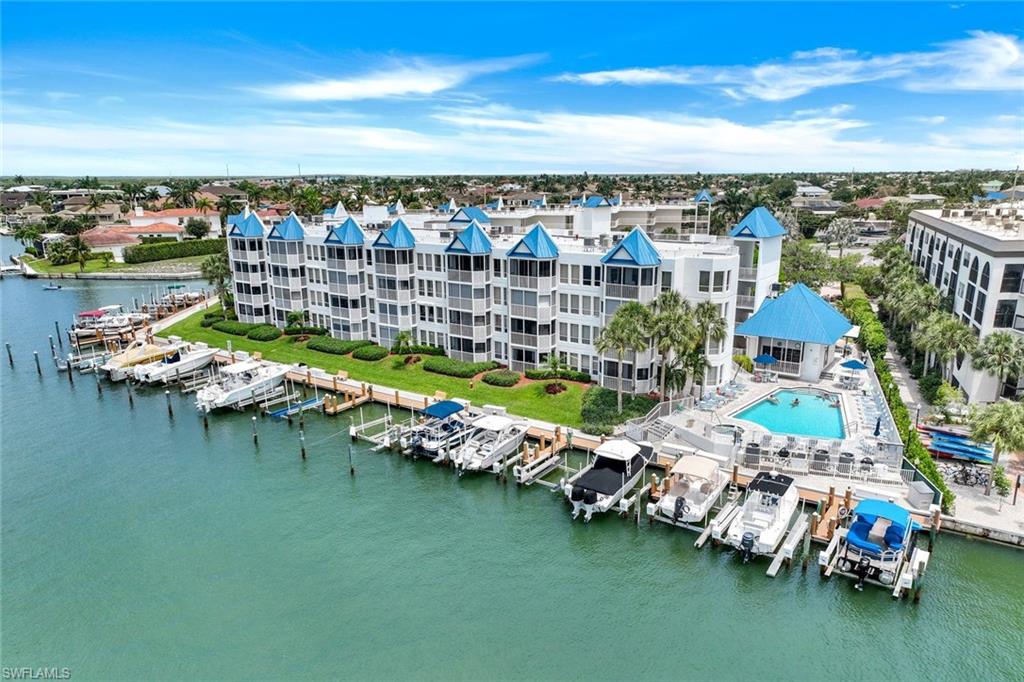 Drone / aerial view of numerous boat docks and a nearby body of water