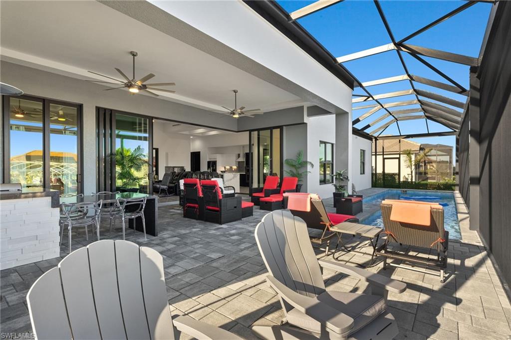 View of patio featuring an outdoor living space, a sunroom, ceiling fan, glass enclosure, and outdoor dining area
