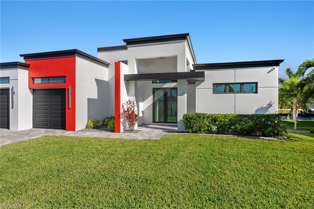 Contemporary home with a front yard, stucco siding, and french doors