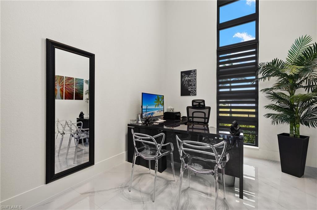 Office space with light marble finish floors and a high ceiling