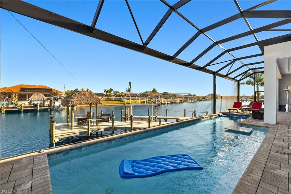 Dock featuring a water view, a sunroom, boat lift, and a lanai