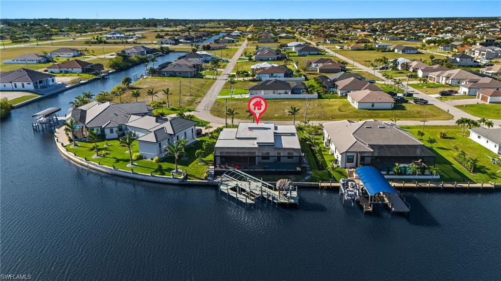 Aerial perspective of suburban area featuring a nearby body of water