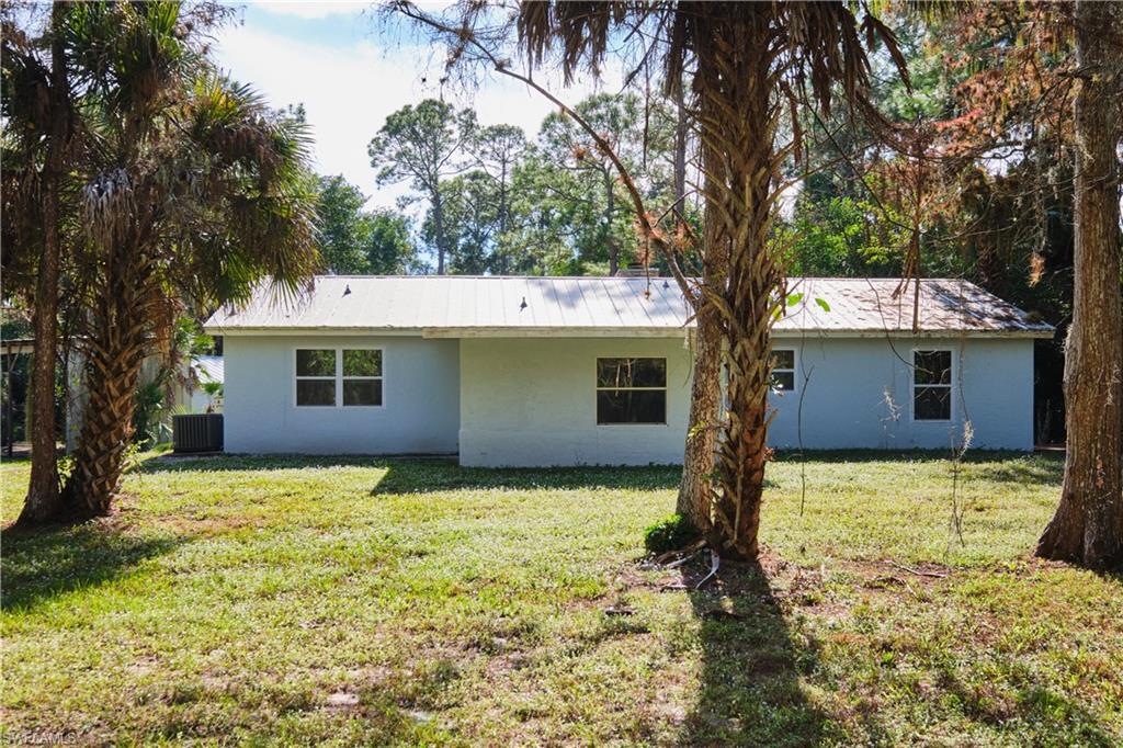 Back of house featuring a yard and stucco siding