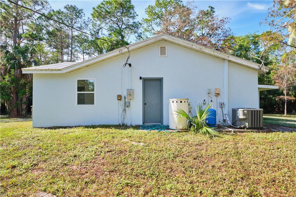 Rear view of property with stucco siding and a yard