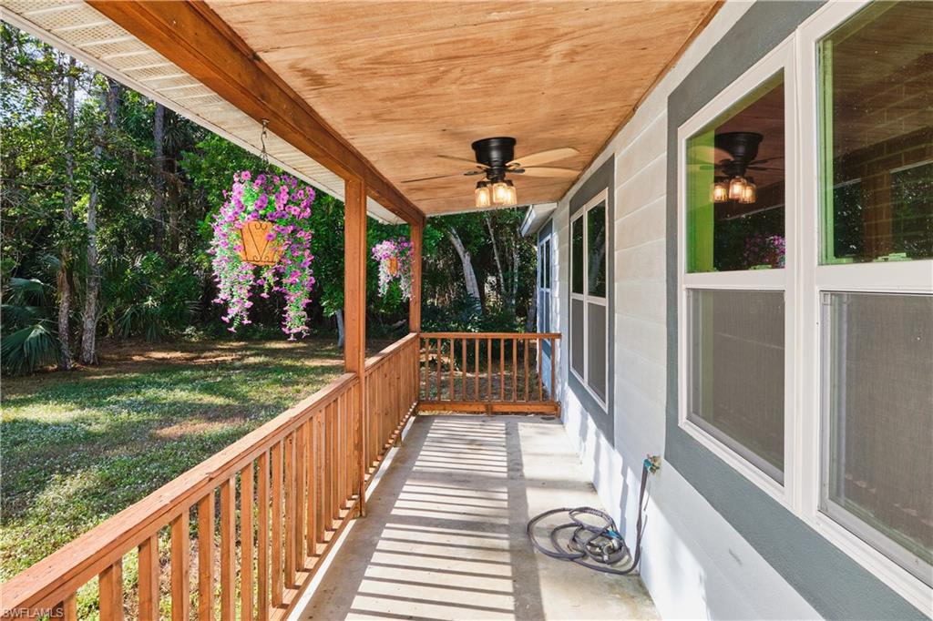 Wooden porch with a ceiling fan and a lawn