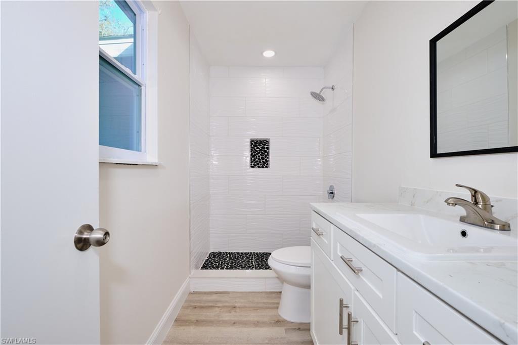 Bathroom with vanity, a stall shower, light wood-type flooring, and recessed lighting